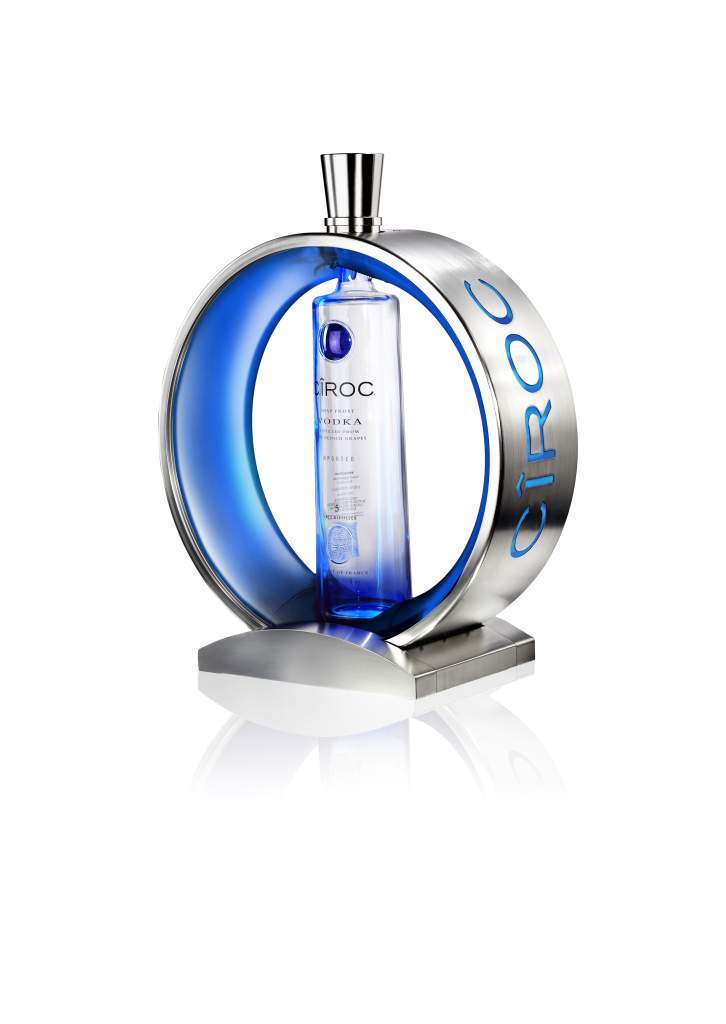 Un rituel de service pour la vodka Ciroc. Le design de cet objet porte l'ADN de la marque avec l'emblème du halo bleu et le look moderne et sophistiqué. Un large anneau entoure et tient la bouteille; son cercle intérieur a la technologie LED bleue insérée