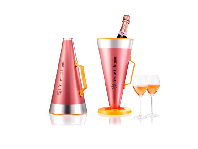 Veuve Clicquot Rosé Scream Your Love is a case containing a megaphone and a bottle of Clicquot Rosé along with two glasses. The megaphone can also be used as an ice bucket to cool the bottle. Cosfibel Premium shaped the coffret into a megaphone and covered it in metallic pink. The use of this bucket-case with megaphone function begins when we turn the large lid and speak from the smaller end