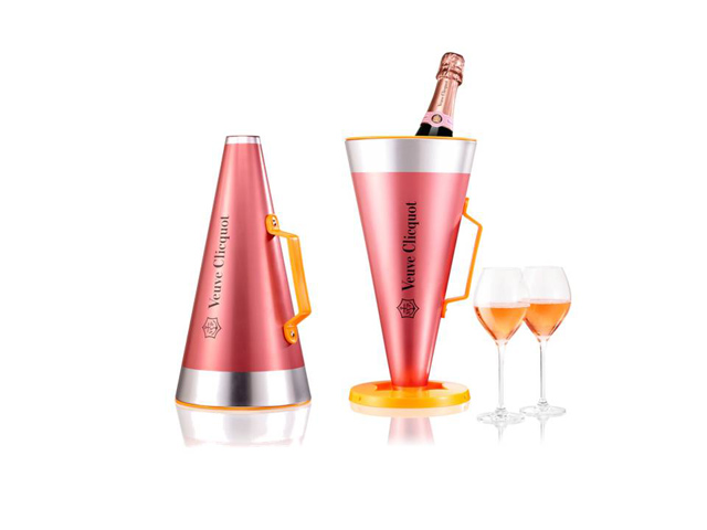 Veuve Clicquot Rosé Scream Your Love ist ein Koffer, der ein Megaphon und eine Flasche Clicquot Rosé sowie zwei Gläser enthält. Das Megaphon kann auch als Eiskübel zum Kühlen der Flasche verwendet werden. Cosfibel Premium gab der Schatulle die Form eines Megaphons und überzog sie mit Metallic-Rosa. Die Nutzung dieser Eiskübelhülle mit Megaphonfunktion beginnt, wenn wir den großen Deckel drehen und durch das kleinere Ende sprechen